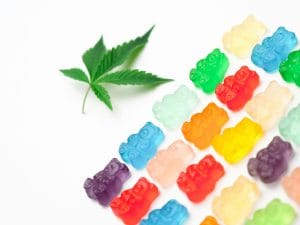 Colorful gummy bears and cannabis leaf